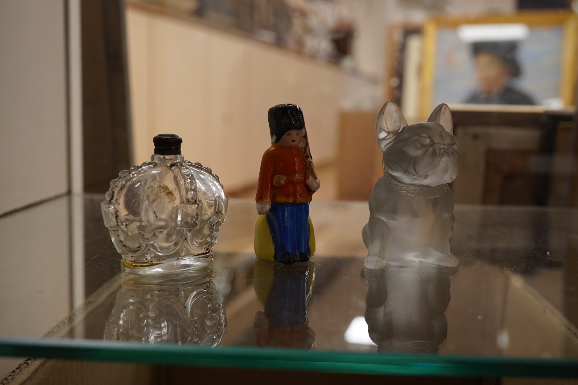 A collection of sundry items to include novelty glass bottles, devil pots and ceramic military caps